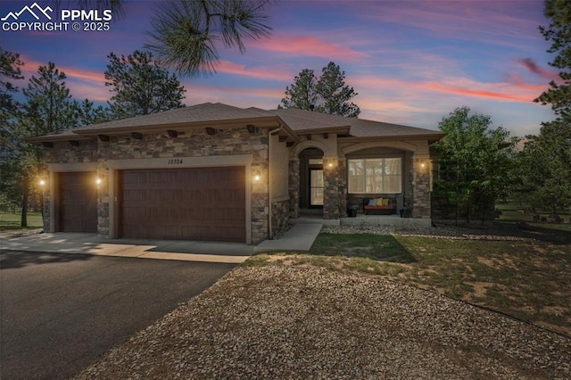 15704 Pole Pine Pt, Colorado Springs, CO 80908 - mediterranean / spanish home with stone siding, asphalt driveway, and a garage