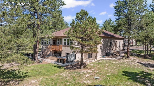 15704 Pole Pine Pt, Colorado Springs, CO 80908 - back of property featuring stucco siding, stairs, and a yard