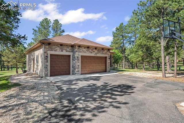15704 Pole Pine Pt, Colorado Springs, CO 80908 - view of side of property with stone siding, driveway, and a garage