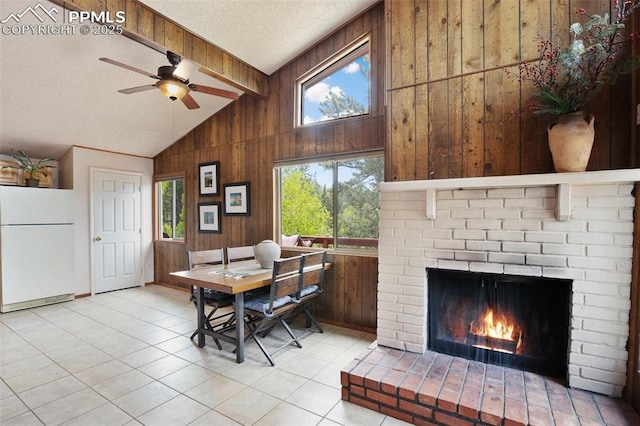 130 Oak Ln, Florissant, CO 80816 - dining area featuring wood walls, a ceiling fan, a textured ceiling, a fireplace, and tile patterned floors