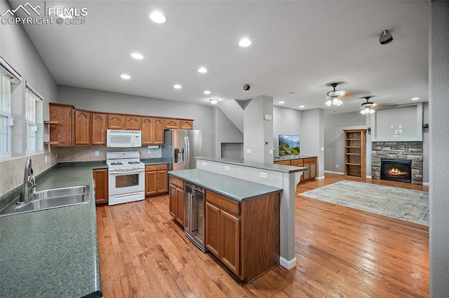 354 Corona Ave, Palmer Lake, CO 80133 - kitchen with white appliances, beverage cooler, ceiling fan, a center island, and light wood-type flooring