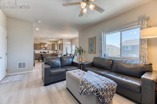 8285 Lodge Grass Way, Colorado Springs, CO 80908 - living room featuring light wood-style floors, ceiling fan, a chandelier, and recessed lighting
