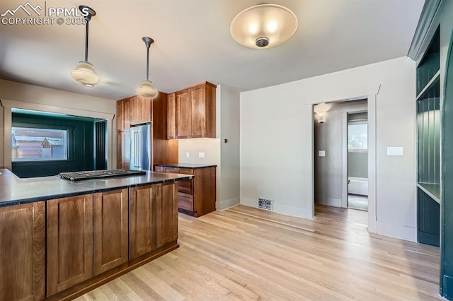 420 E Fontanero St, Colorado Springs, CO 80907 - kitchen with dark countertops, appliances with stainless steel finishes, light wood-style floors, and brown cabinets