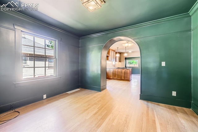 420 E Fontanero St, Colorado Springs, CO 80907 - empty room with arched walkways, ornamental molding, and light wood-style floors