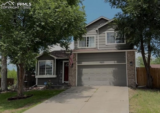 4530 W Jet Wing Cir, Colorado Springs, CO 80916 - view of front of house featuring concrete driveway, an attached garage, and brick siding