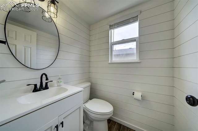 4530 W Jet Wing Cir, Colorado Springs, CO 80916 - half bathroom with vanity, wood finished floors, and wooden walls