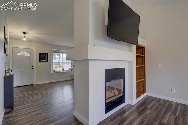 4530 W Jet Wing Cir, Colorado Springs, CO 80916 - unfurnished living room with dark wood-type flooring and a glass covered fireplace