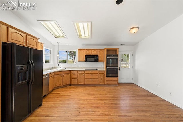 3970 Old Ranch Rd, Colorado Springs, CO 80908 - kitchen with black appliances, light countertops, light wood-style floors, and hanging light fixtures