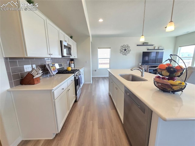 8136 Kittrick Pl, Peyton, CO 80831 - kitchen with stainless steel appliances, light wood-style flooring, white cabinetry, light countertops, and recessed lighting