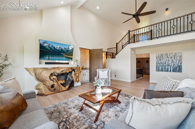 780 Mission Hill Way, Colorado Springs, CO 80921 - living area with high vaulted ceiling, light wood-style floors, a ceiling fan, a stone fireplace, and stairway