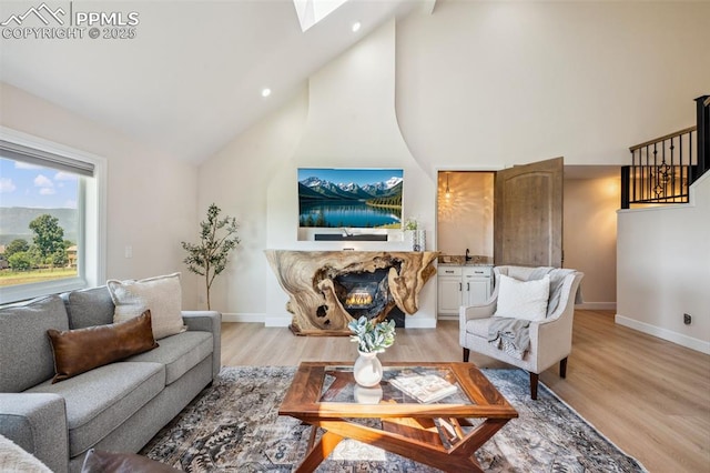 780 Mission Hill Way, Colorado Springs, CO 80921 - living room featuring high vaulted ceiling, a warm lit fireplace, a skylight, light wood finished floors, and recessed lighting