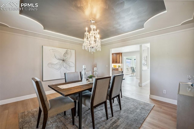 780 Mission Hill Way, Colorado Springs, CO 80921 - dining area featuring a tray ceiling, a chandelier, and light wood-type flooring