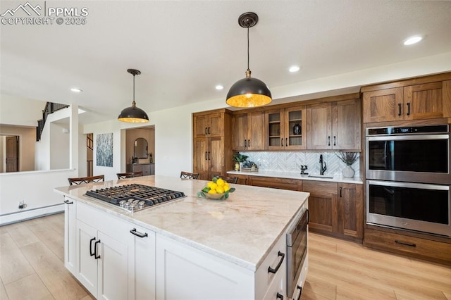 780 Mission Hill Way, Colorado Springs, CO 80921 - kitchen featuring stainless steel appliances, glass insert cabinets, light wood finished floors, hanging light fixtures, and recessed lighting