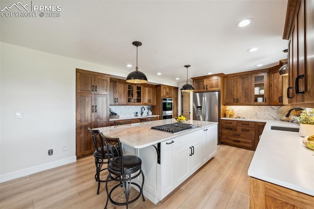 780 Mission Hill Way, Colorado Springs, CO 80921 - kitchen with stainless steel appliances, a kitchen island, recessed lighting, brown cabinets, and light wood-style flooring