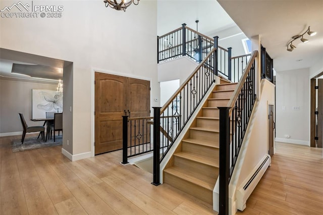 780 Mission Hill Way, Colorado Springs, CO 80921 - stairs with a chandelier, hardwood / wood-style flooring, baseboard heating, and a high ceiling