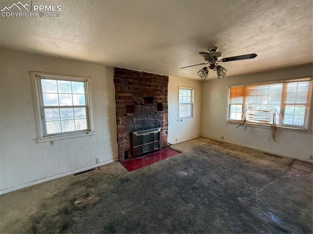 1117 E 6th St, La Junta, CO 81050 - unfurnished living room featuring a textured ceiling, a fireplace, ceiling fan, and carpet flooring