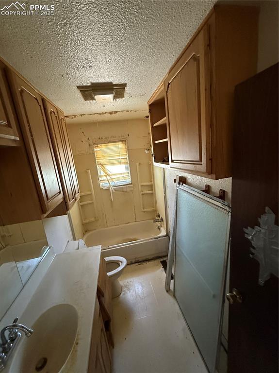 1117 E 6th St, La Junta, CO 81050 - bathroom with a textured ceiling, shower / bathtub combination, and vanity