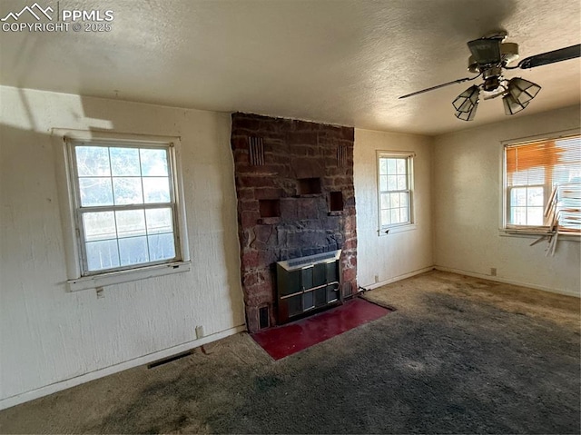 1117 E 6th St, La Junta, CO 81050 - unfurnished living room with a textured ceiling, carpet, a ceiling fan, and a fireplace