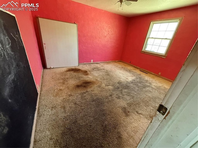 1117 E 6th St, La Junta, CO 81050 - carpeted empty room with a textured wall, ceiling fan, and a textured ceiling