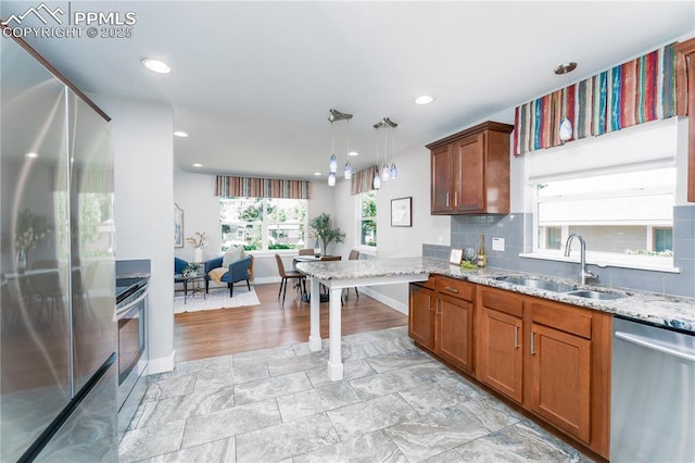 1514 W Platte Ave, Colorado Springs, CO 80904 - kitchen featuring stainless steel appliances, light stone counters, recessed lighting, hanging light fixtures, and brown cabinets