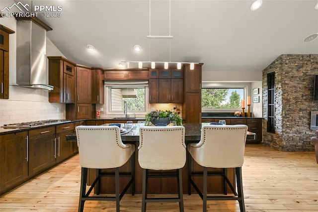 1282 Hill Cir, Colorado Springs, CO 80904 - kitchen featuring decorative backsplash, a kitchen island, glass insert cabinets, light wood finished floors, and recessed lighting