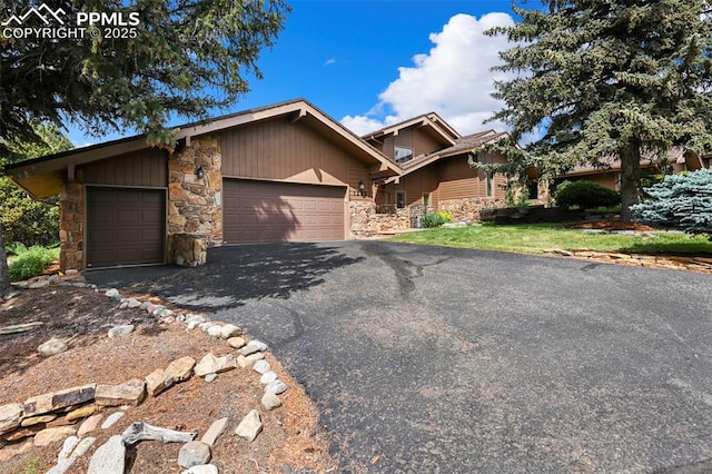 1282 Hill Cir, Colorado Springs, CO 80904 - view of front of house featuring stone siding, a garage, and asphalt driveway