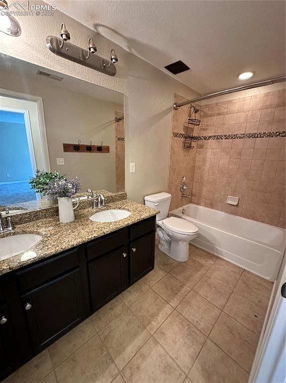 9767 Carnival Ln, Fountain, CO 80817 - bathroom with tile patterned floors, double vanity, and washtub / shower combination