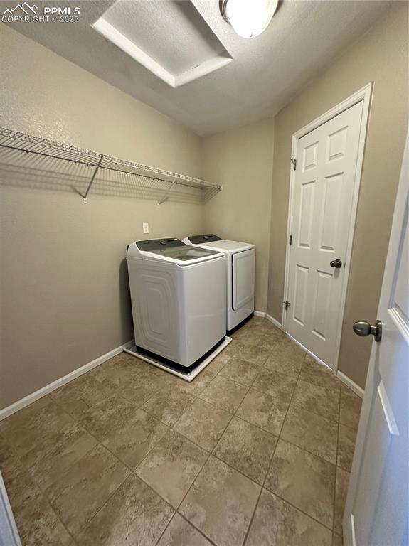 9767 Carnival Ln, Fountain, CO 80817 - washroom featuring washing machine and clothes dryer and tile patterned flooring