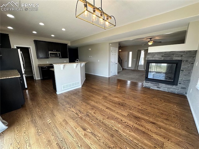 9767 Carnival Ln, Fountain, CO 80817 - kitchen with stainless steel appliances, dark cabinetry, light countertops, dark wood-style floors, and open floor plan