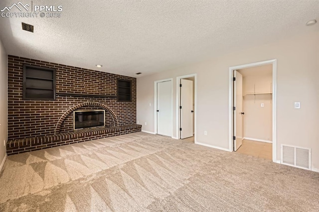 7025 Nettlewood Pl, Colorado Springs, CO 80918 - unfurnished living room with carpet floors, a textured ceiling, and a brick fireplace