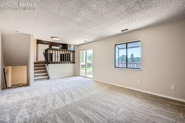 7025 Nettlewood Pl, Colorado Springs, CO 80918 - unfurnished living room featuring stairway, a textured ceiling, and light colored carpet