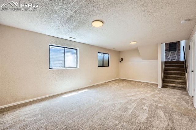 7025 Nettlewood Pl, Colorado Springs, CO 80918 - below grade area with a textured wall, stairway, carpet flooring, and a textured ceiling
