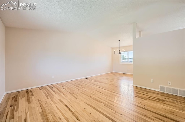 7025 Nettlewood Pl, Colorado Springs, CO 80918 - spare room featuring a chandelier, light wood finished floors, and a textured ceiling