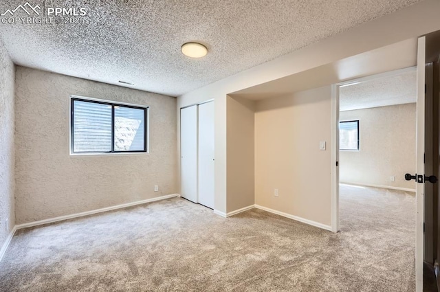 7025 Nettlewood Pl, Colorado Springs, CO 80918 - unfurnished bedroom with carpet, multiple windows, a textured ceiling, a closet, and a textured wall