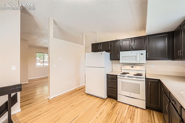 7025 Nettlewood Pl, Colorado Springs, CO 80918 - kitchen with white appliances, light countertops, light wood-style floors, and a textured ceiling