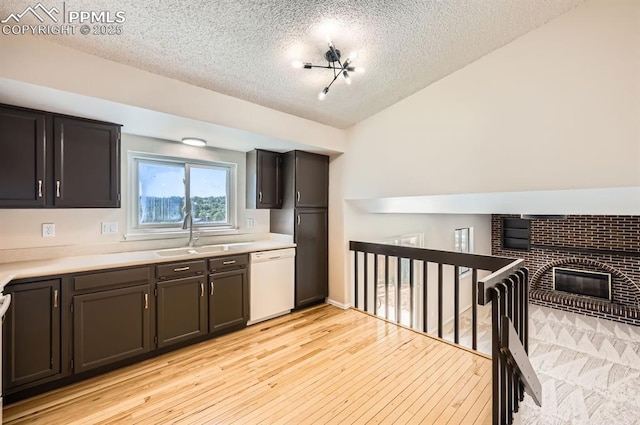 7025 Nettlewood Pl, Colorado Springs, CO 80918 - kitchen featuring dishwasher, a textured ceiling, light countertops, light wood finished floors, and a brick fireplace