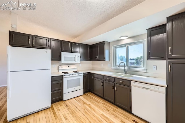 7025 Nettlewood Pl, Colorado Springs, CO 80918 - kitchen with white appliances, light wood-type flooring, a textured ceiling, and light countertops