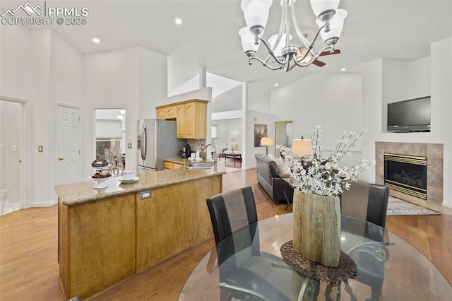 10 Desert Inn Way, Colorado Springs, CO 80921 - dining space featuring a chandelier, high vaulted ceiling, light wood finished floors, a tiled fireplace, and recessed lighting