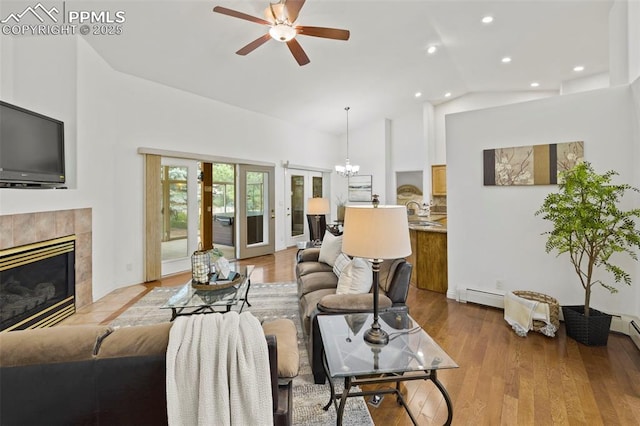 10 Desert Inn Way, Colorado Springs, CO 80921 - living area with a baseboard heating unit, a ceiling fan, a tiled fireplace, a chandelier, and wood finished floors