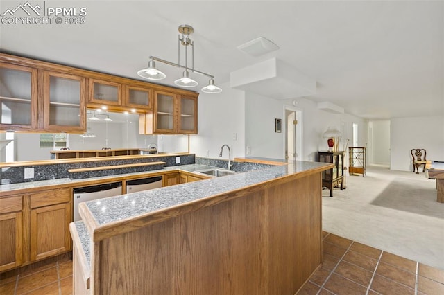 10 Desert Inn Way, Colorado Springs, CO 80921 - kitchen with brown cabinets, dark colored carpet, glass insert cabinets, and hanging light fixtures