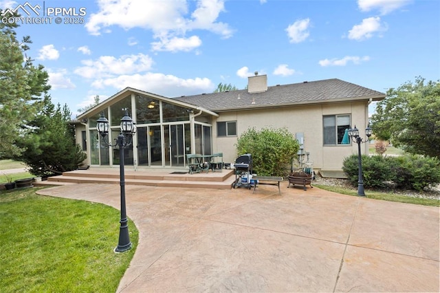 10 Desert Inn Way, Colorado Springs, CO 80921 - rear view of house with a sunroom, stucco siding, a patio, a chimney, and a yard