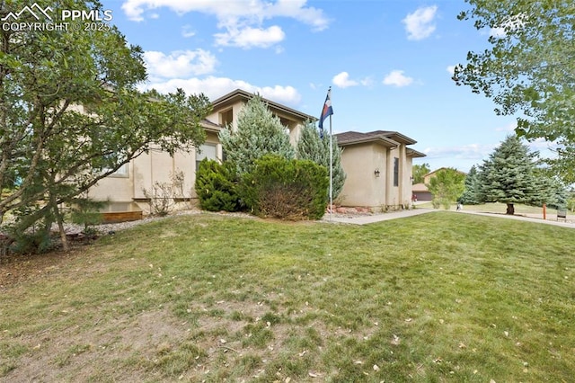 10 Desert Inn Way, Colorado Springs, CO 80921 - rear view of house featuring stucco siding and a yard