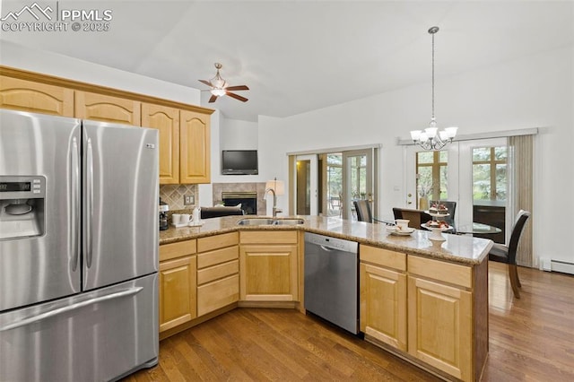 10 Desert Inn Way, Colorado Springs, CO 80921 - kitchen with appliances with stainless steel finishes, light brown cabinets, a peninsula, and wood finished floors