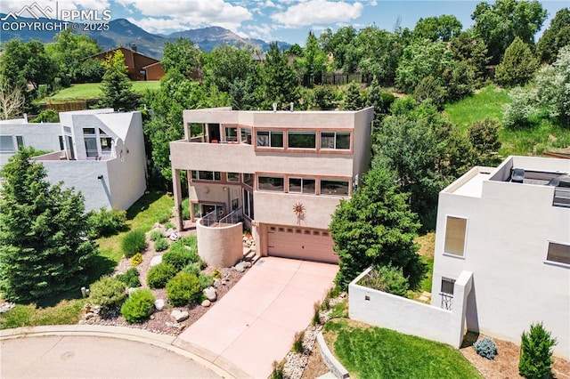 616 Tierra Verde Ct, Colorado Springs, CO 80904 - view of front of house with an attached garage, driveway, a balcony, stucco siding, and a mountain view