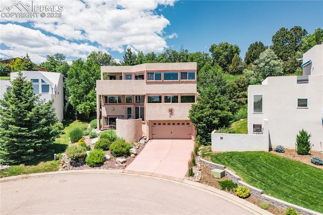 616 Tierra Verde Ct, Colorado Springs, CO 80904 - view of front facade with an attached garage, concrete driveway, stucco siding, and a front lawn