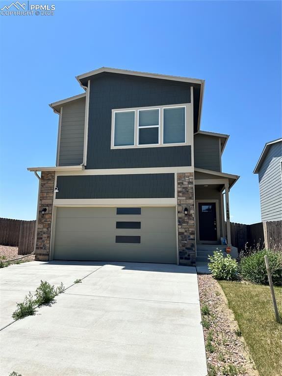 11489 Piping Plover Pl, Colorado Springs, CO 80925 - view of front facade featuring stone siding, concrete driveway, and a garage