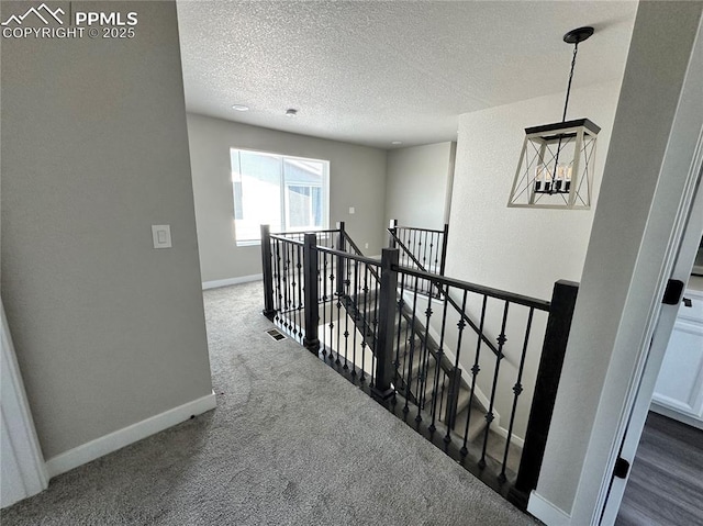 11489 Piping Plover Pl, Colorado Springs, CO 80925 - hallway featuring an upstairs landing, a textured ceiling, and dark colored carpet