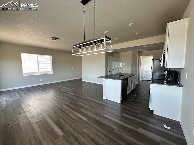 11489 Piping Plover Pl, Colorado Springs, CO 80925 - kitchen with white cabinets, dark wood-type flooring, a textured ceiling, open floor plan, and an island with sink