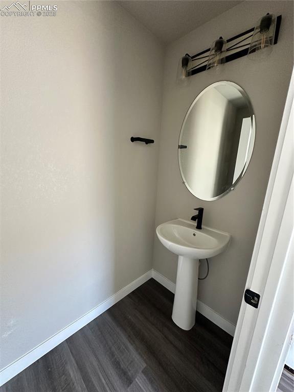 11489 Piping Plover Pl, Colorado Springs, CO 80925 - bathroom featuring wood finished floors and baseboards