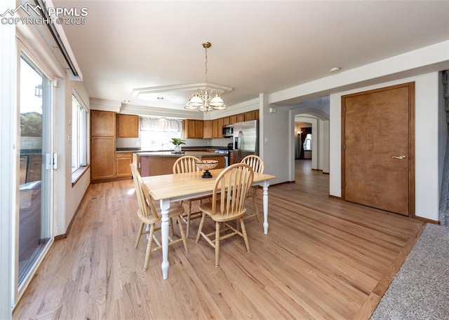 2457 Craycroft Dr, Colorado Springs, CO 80920 - dining room with arched walkways, light wood-type flooring, and a chandelier